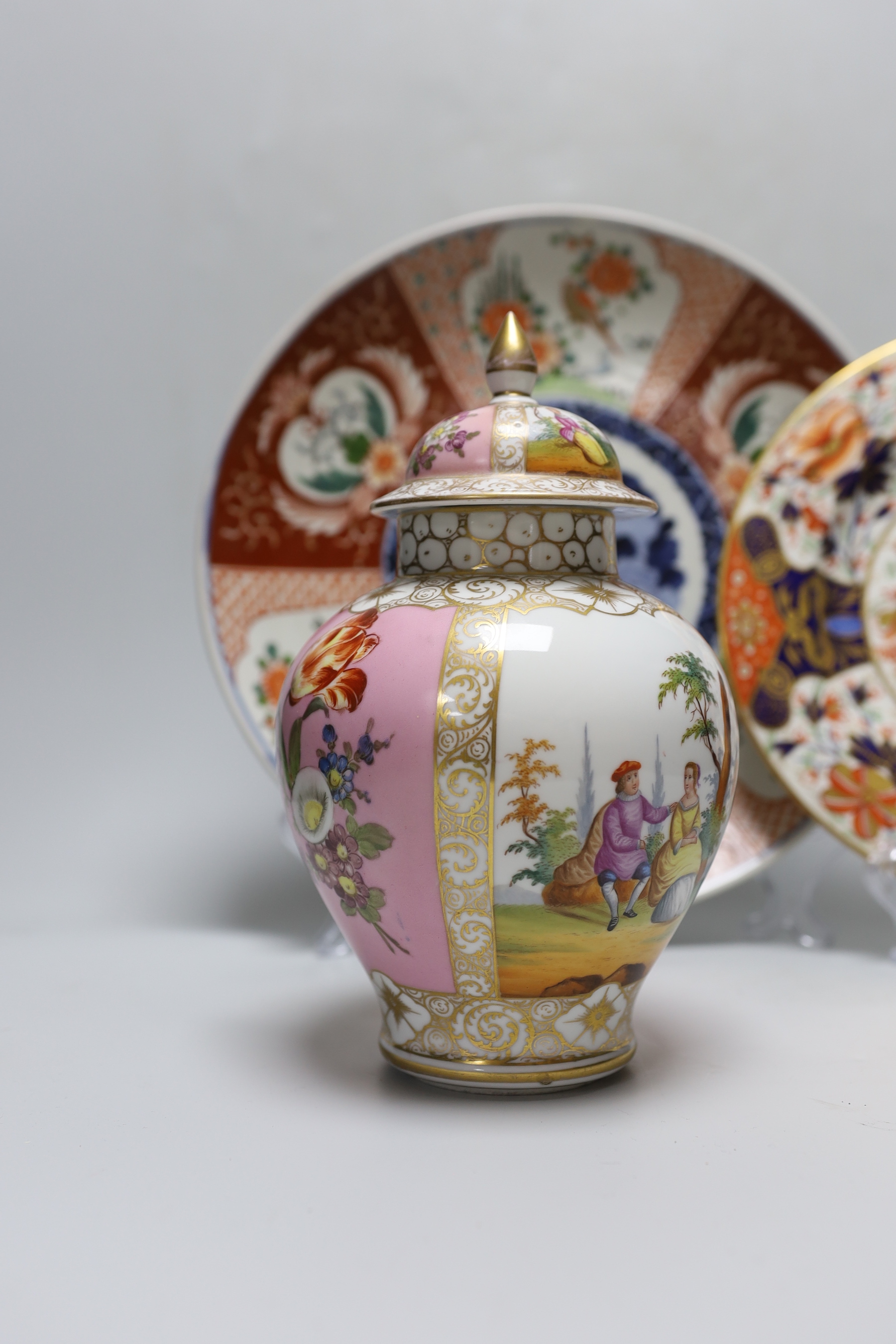 A Dresden pink ground jar and cover with gilt and floral decoration, 23cm tall, an Imari charger and a Royal Crown Derby plate